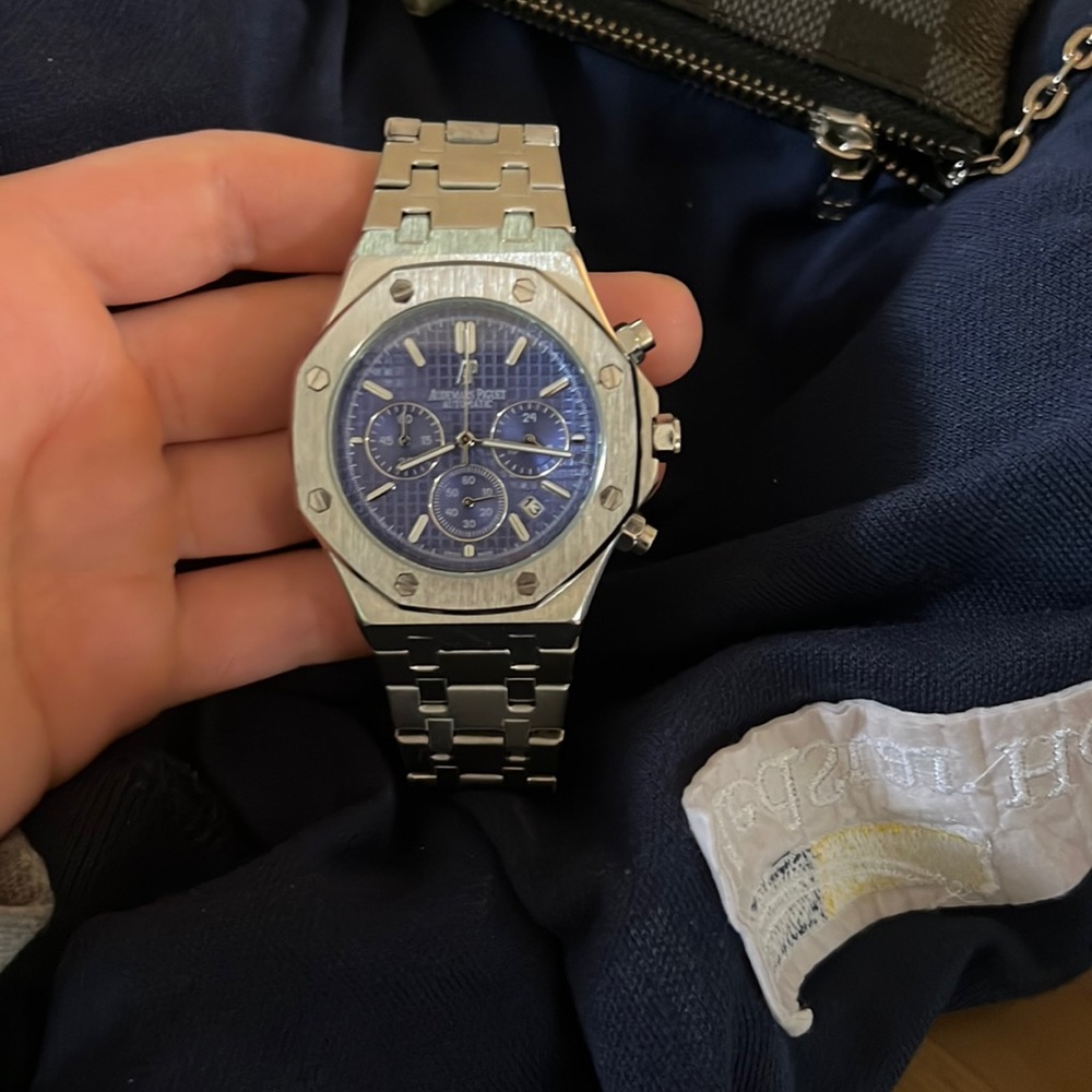 Silver watch with blue face. It’s a R E P L I C A